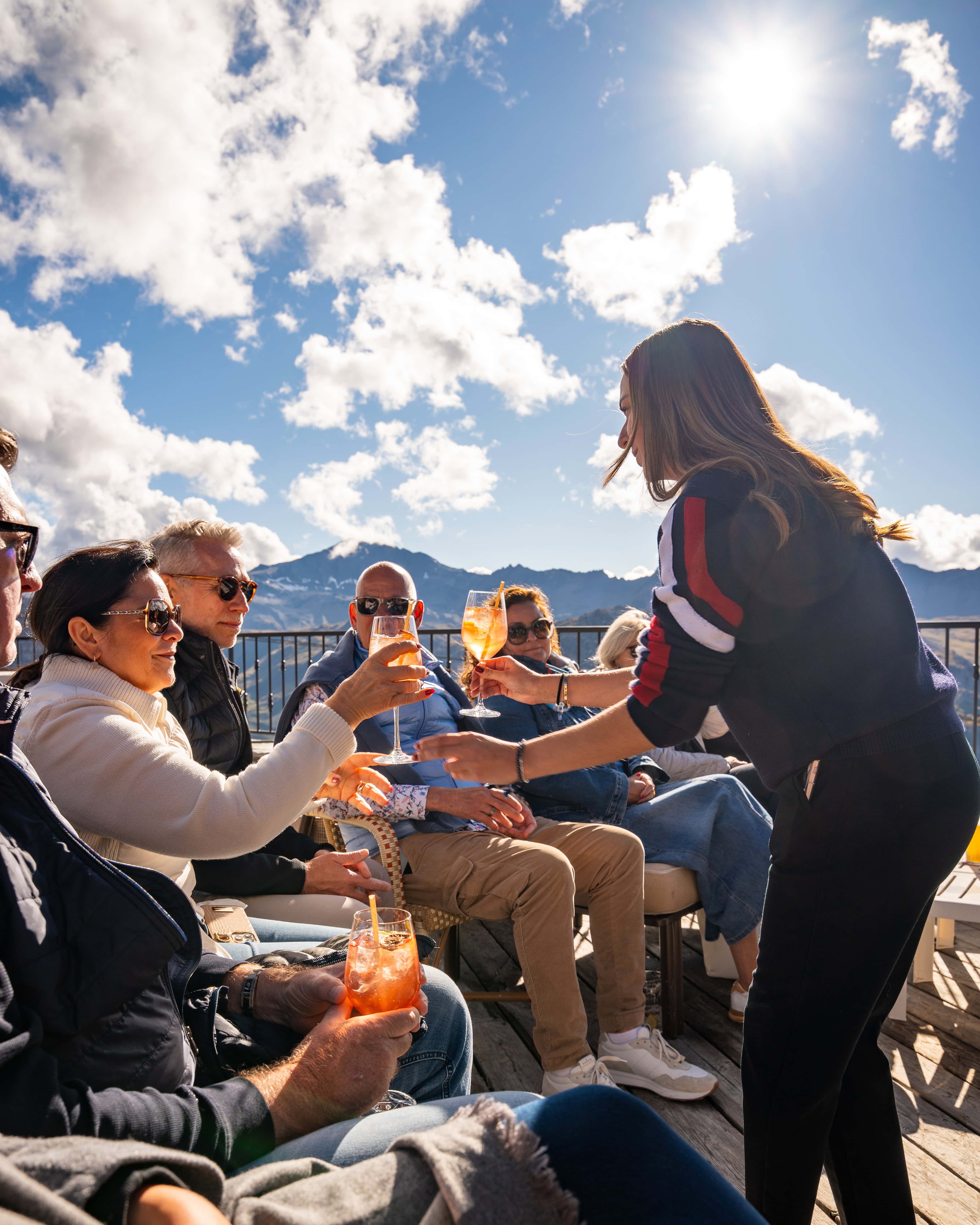 Genussvolle Momente mit erfrischenden Cocktails, umgeben von atemberaubender Berglandschaft und strahlendem Sonnenschein.